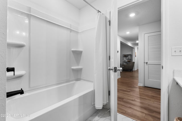 bathroom with hardwood / wood-style flooring and shower / tub combo