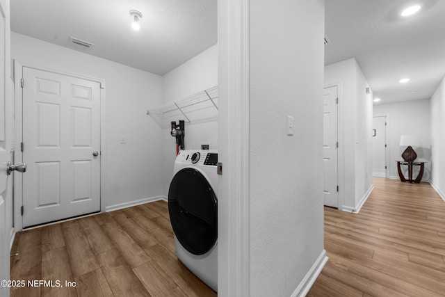 laundry area featuring washer / clothes dryer and light wood-type flooring