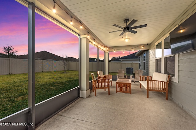 sunroom featuring a healthy amount of sunlight, track lighting, and ceiling fan