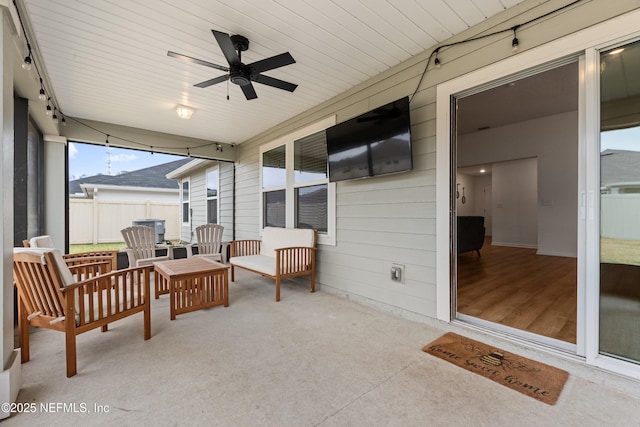 sunroom / solarium featuring rail lighting and ceiling fan