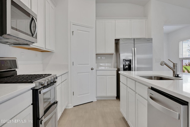 348 Salazar St, Saint Augustine, FL 32095 - kitchen with appliances with stainless steel finishes, white cabinets, light countertops, and light wood-style flooring