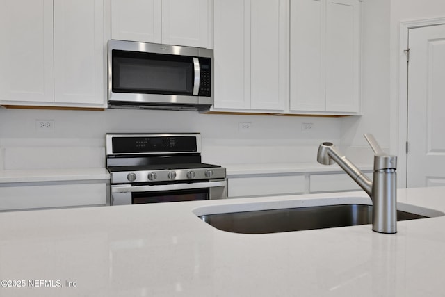 348 Salazar St, Saint Augustine, FL 32095 - kitchen featuring stainless steel appliances, light countertops, and white cabinetry