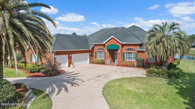 view of front of home featuring a garage, a front lawn, and a water view