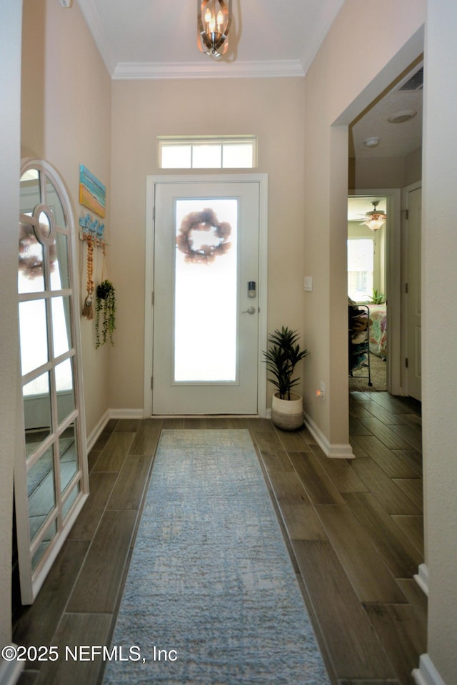 entrance foyer with ornamental molding, a wealth of natural light, and a notable chandelier