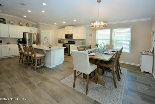 dining area with sink and crown molding