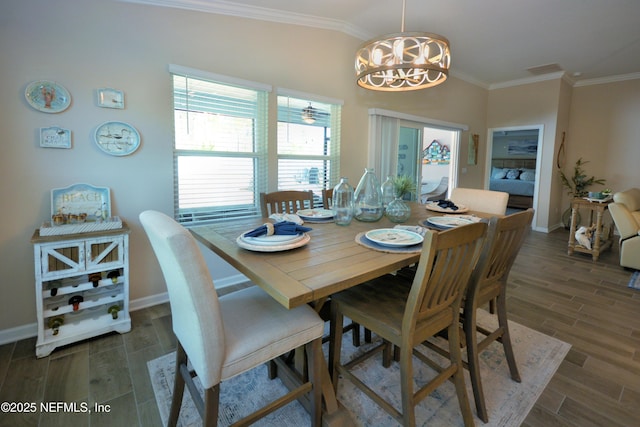 dining room with ornamental molding, lofted ceiling, and a notable chandelier