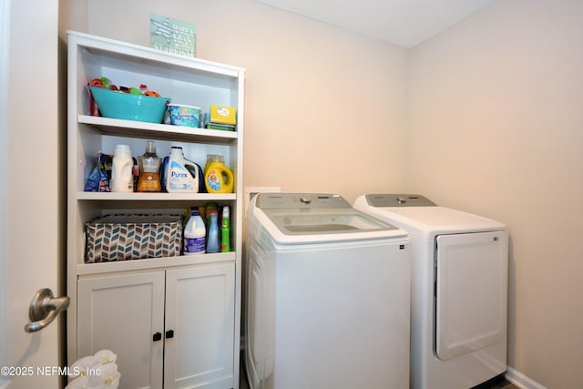 clothes washing area with cabinets and washing machine and clothes dryer