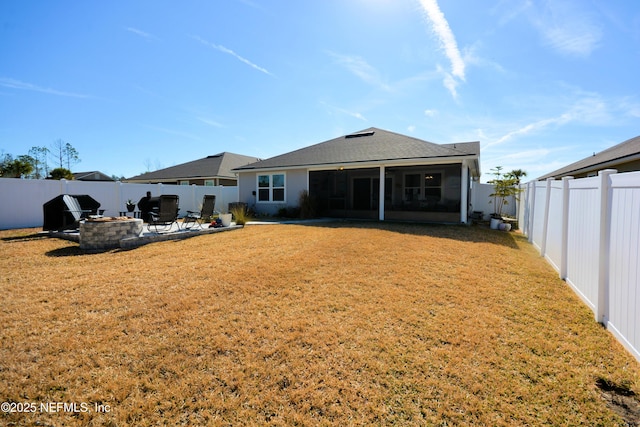 rear view of property with a yard, a patio area, and a fire pit