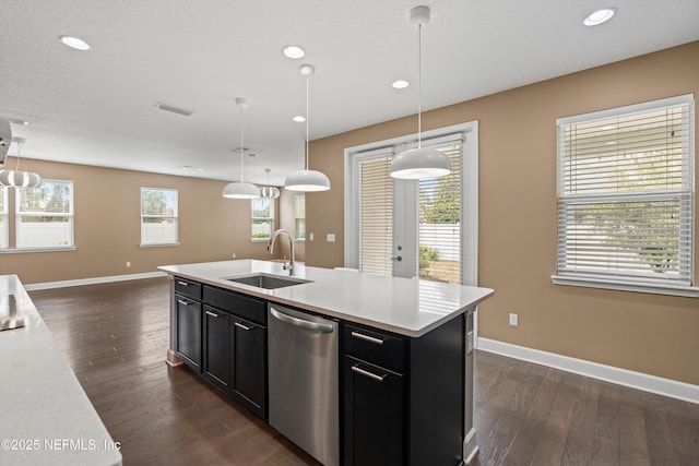 kitchen featuring pendant lighting, an island with sink, dishwasher, and sink