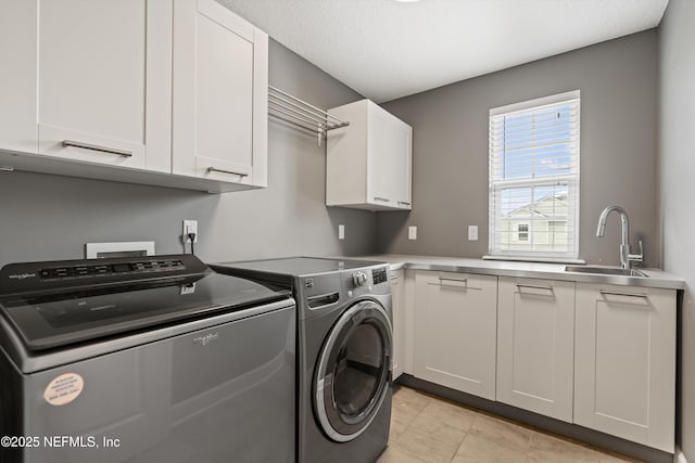 laundry room with cabinets, sink, washer and dryer, and light tile patterned flooring