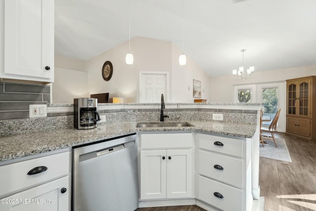 kitchen with a peninsula, a sink, white cabinetry, dishwasher, and decorative light fixtures