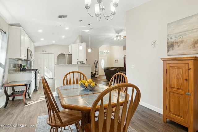 dining area with lofted ceiling, dark wood-style floors, visible vents, and baseboards