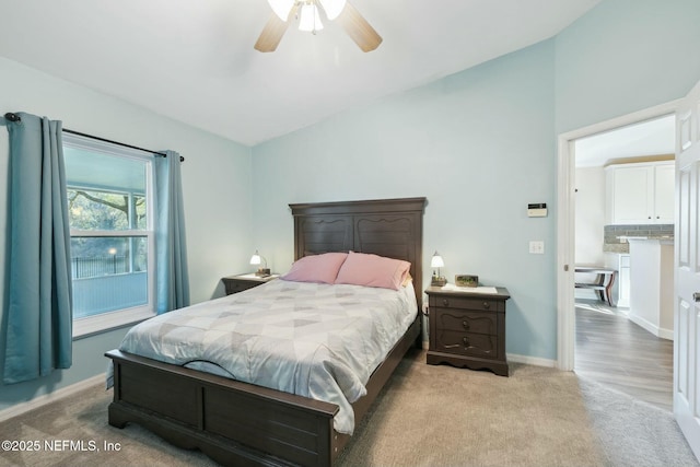 bedroom with lofted ceiling, ceiling fan, light carpet, and baseboards