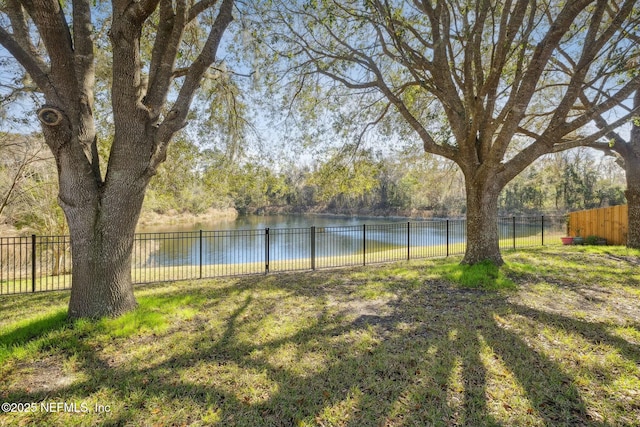 view of yard with a water view and fence