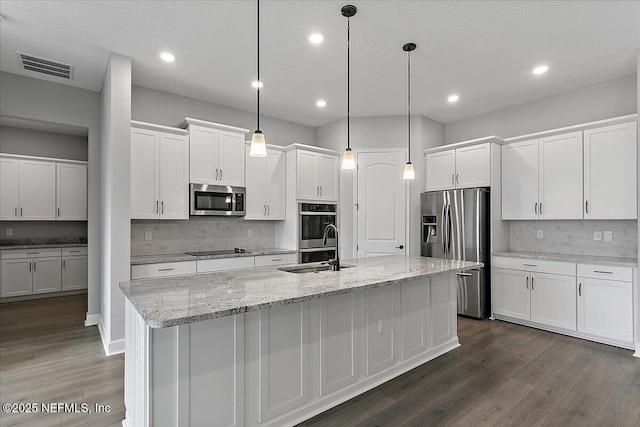 kitchen with stainless steel appliances, a kitchen island with sink, and white cabinets