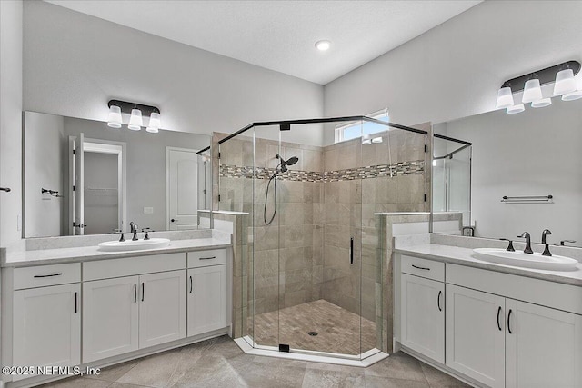 bathroom with two vanities, a sink, and a shower stall