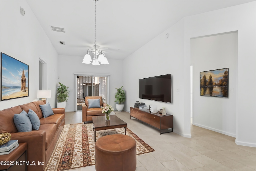 living room featuring an inviting chandelier, lofted ceiling, and light tile patterned flooring