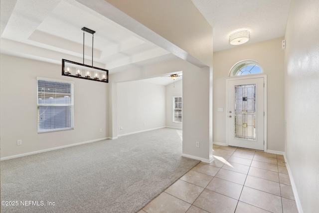 carpeted foyer entrance with a tray ceiling and ceiling fan