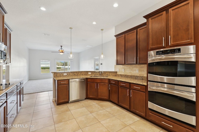 4468 Song Sparrow Dr, Middleburg, FL 32068 - kitchen with hanging light fixtures, stainless steel appliances, kitchen peninsula, and light stone countertops