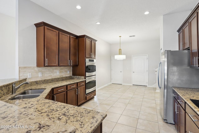 4468 Song Sparrow Dr, Middleburg, FL 32068 - kitchen with light stone countertops, sink, pendant lighting, and decorative backsplash