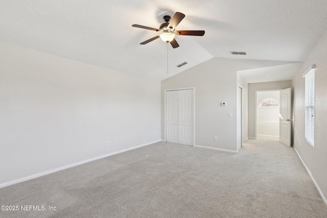 4468 Song Sparrow Dr, Middleburg, FL 32068 - unfurnished bedroom featuring vaulted ceiling, light colored carpet, ceiling fan, a textured ceiling, and a closet