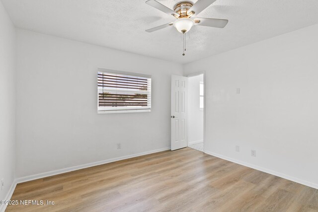 unfurnished room featuring baseboards, a textured ceiling, ceiling fan, and wood finished floors