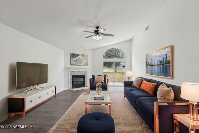 living room with dark hardwood / wood-style flooring, vaulted ceiling, a tile fireplace, and ceiling fan