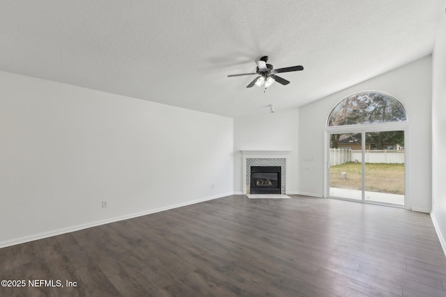 unfurnished living room featuring a tile fireplace, dark hardwood / wood-style floors, a textured ceiling, and ceiling fan