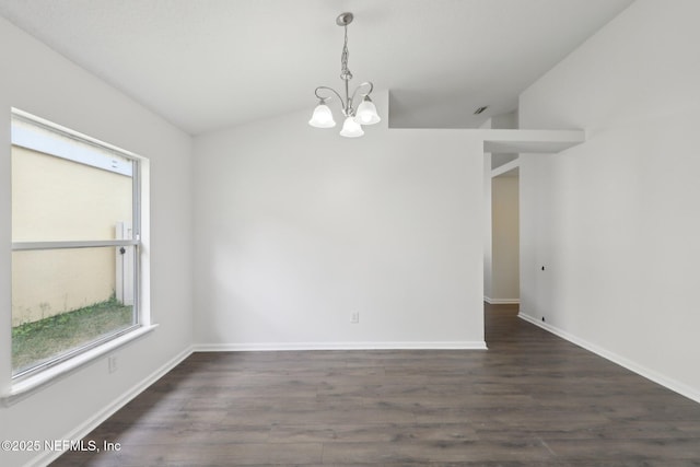 empty room featuring an inviting chandelier, vaulted ceiling, and dark hardwood / wood-style floors