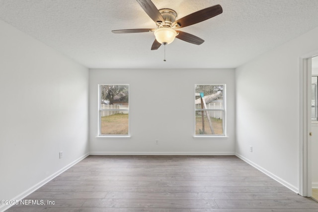 spare room with hardwood / wood-style floors, a textured ceiling, and ceiling fan
