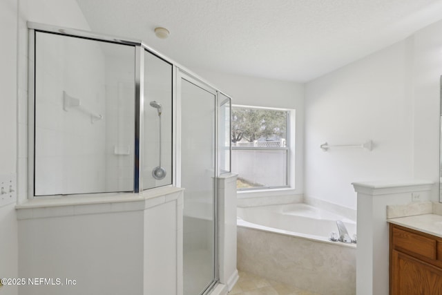 bathroom featuring vanity, independent shower and bath, and a textured ceiling