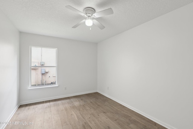 spare room with ceiling fan, a textured ceiling, and light hardwood / wood-style floors