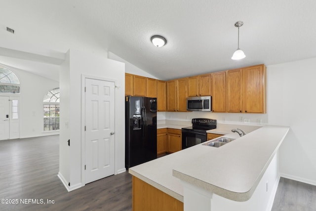 kitchen with lofted ceiling, sink, black appliances, decorative light fixtures, and kitchen peninsula