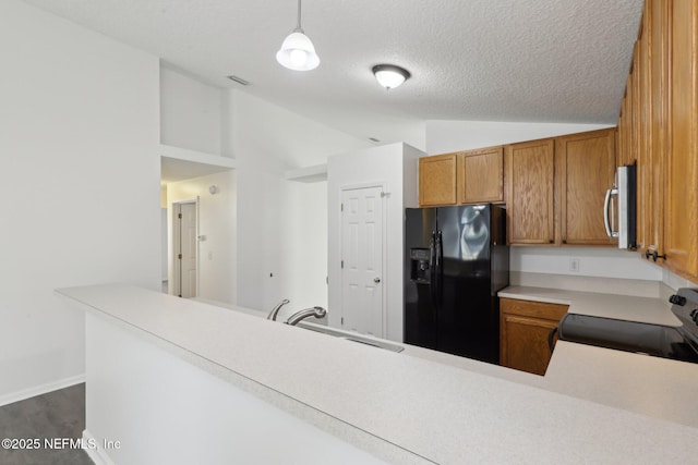 kitchen with lofted ceiling, sink, range with electric cooktop, decorative light fixtures, and black refrigerator with ice dispenser