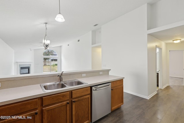 kitchen with lofted ceiling, sink, dishwasher, hanging light fixtures, and dark hardwood / wood-style flooring