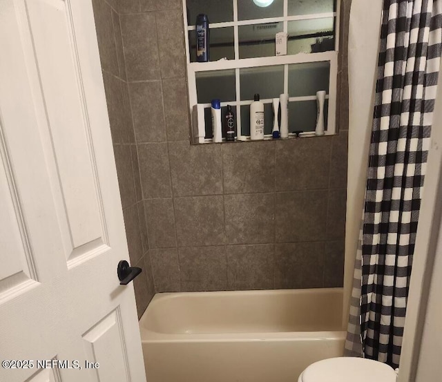 bathroom with shower / bath combination with curtain and toilet