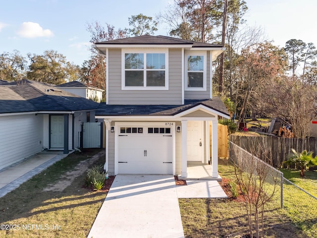 view of property featuring a garage and a front lawn