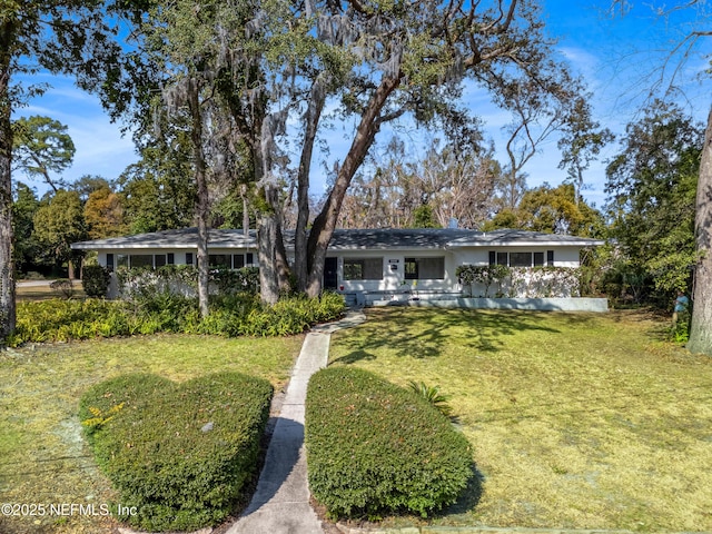 single story home featuring a front lawn