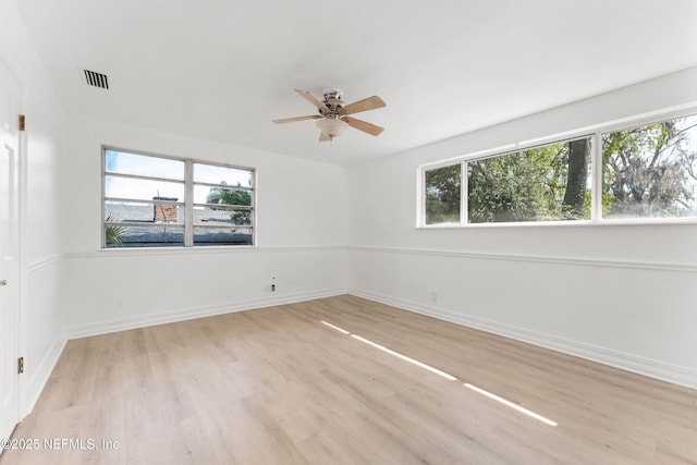 unfurnished room featuring light wood-type flooring, baseboards, visible vents, and a ceiling fan