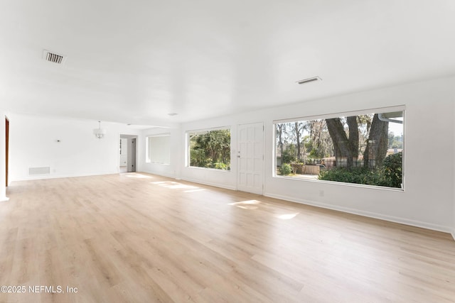 unfurnished living room with light wood finished floors and visible vents