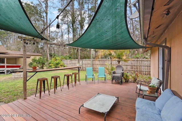 wooden terrace featuring a lawn and a fenced backyard