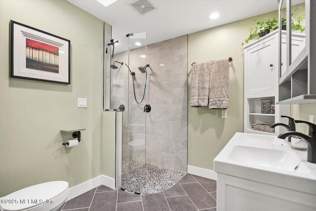 bathroom with toilet, visible vents, baseboards, a tile shower, and tile patterned floors