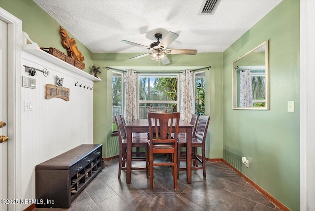 dining area with a ceiling fan, visible vents, a textured ceiling, and baseboards