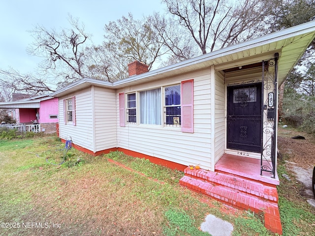 doorway to property with a yard