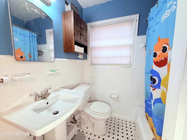 full bathroom with tile walls, sink, toilet, and shower / bathtub combination with curtain