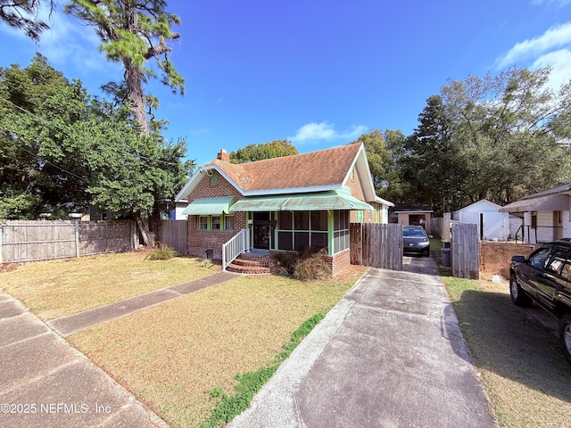 bungalow featuring a front lawn and a sunroom