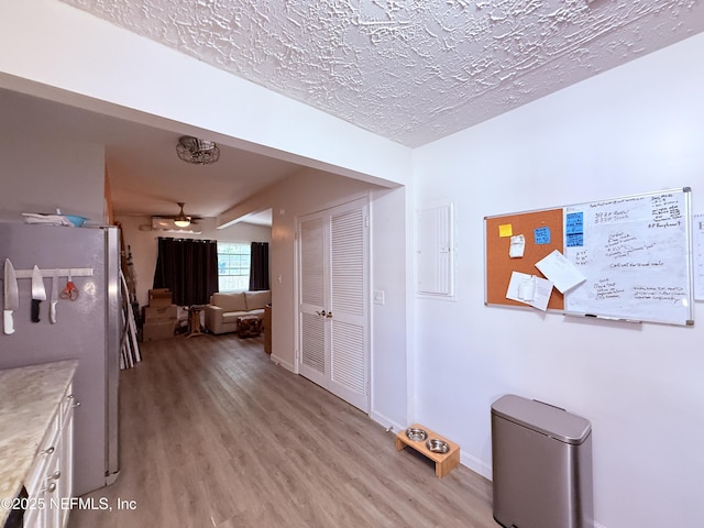 hallway featuring a textured ceiling and light wood-type flooring