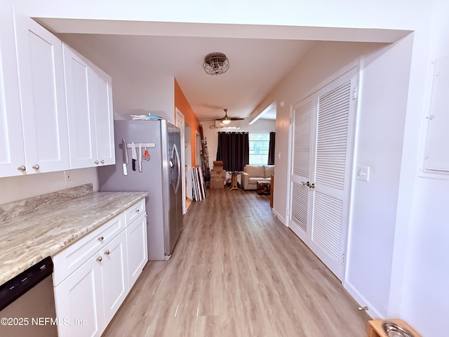 kitchen with light stone countertops, light hardwood / wood-style flooring, stainless steel appliances, and white cabinets