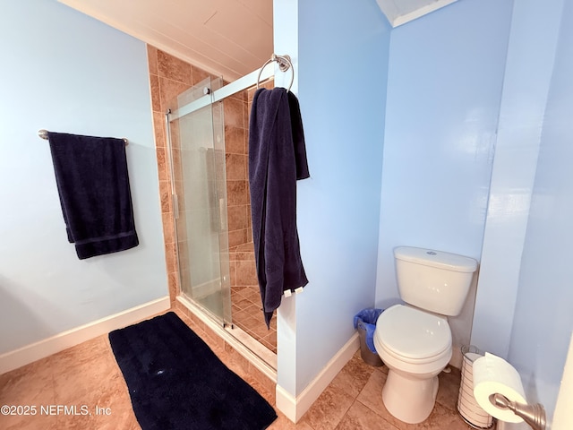 bathroom with tile patterned flooring, toilet, and a shower with shower door