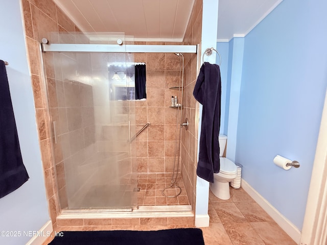 bathroom featuring a shower with shower door, ornamental molding, and toilet